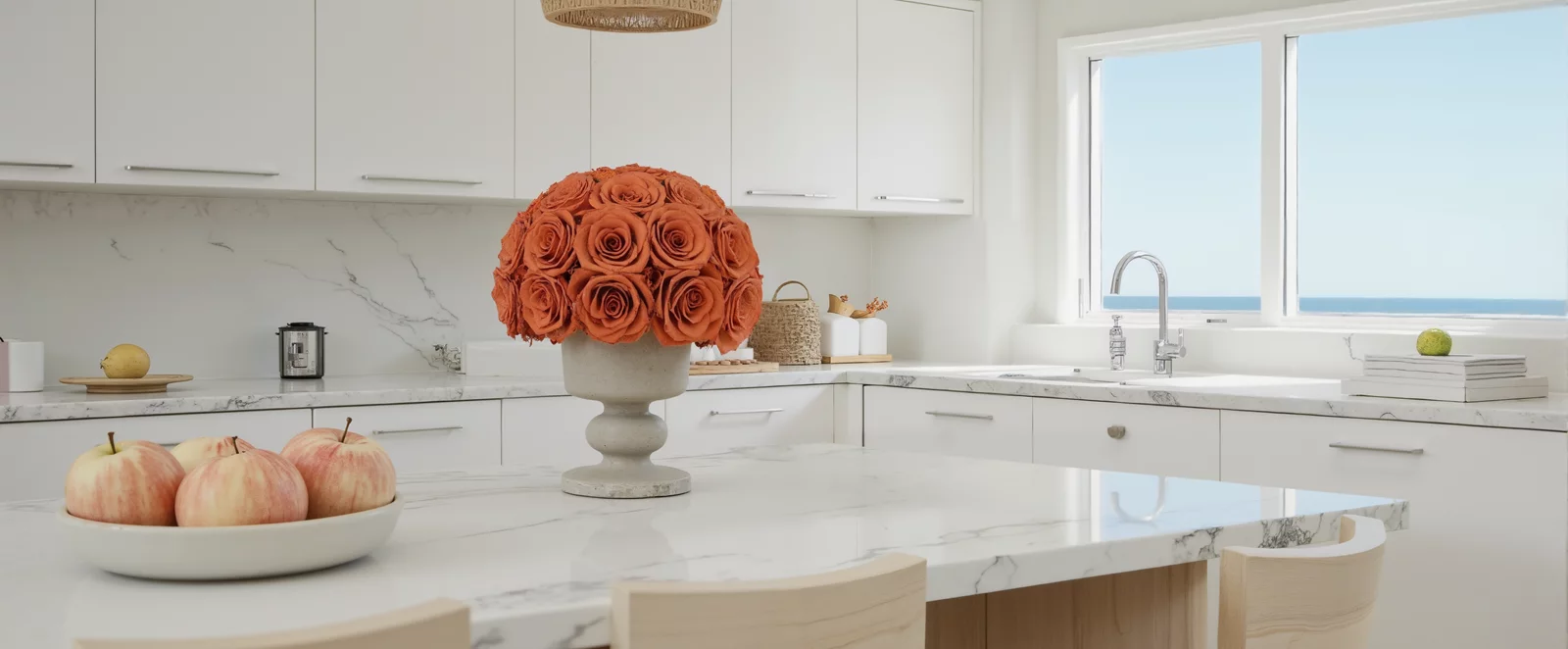 White ceramic vase with orange roses on a kitchen island, minimalist floral centerpiece.