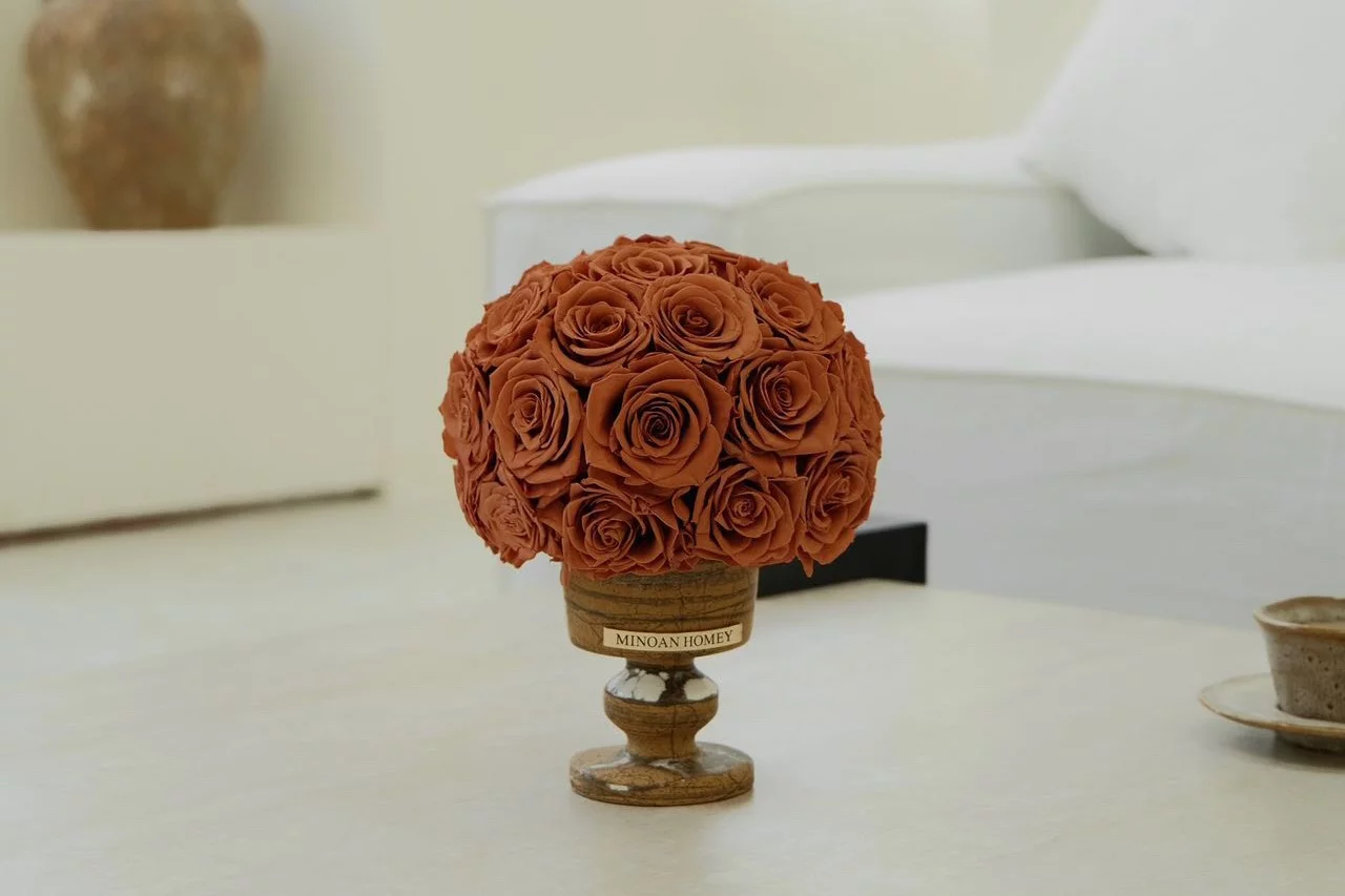 Rustic wooden vase with red rose bouquet in minimalist sunlit living room