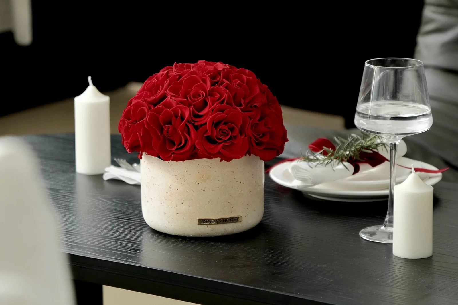 Minimalist dining setup with red roses and candles