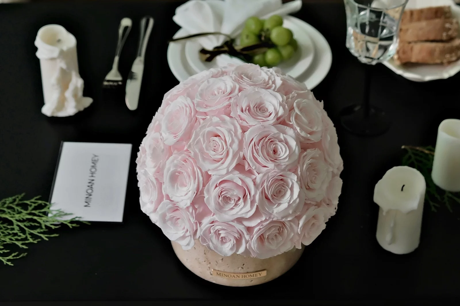 Sophisticated table setting with pink and white rose arrangement on beige wooden platter