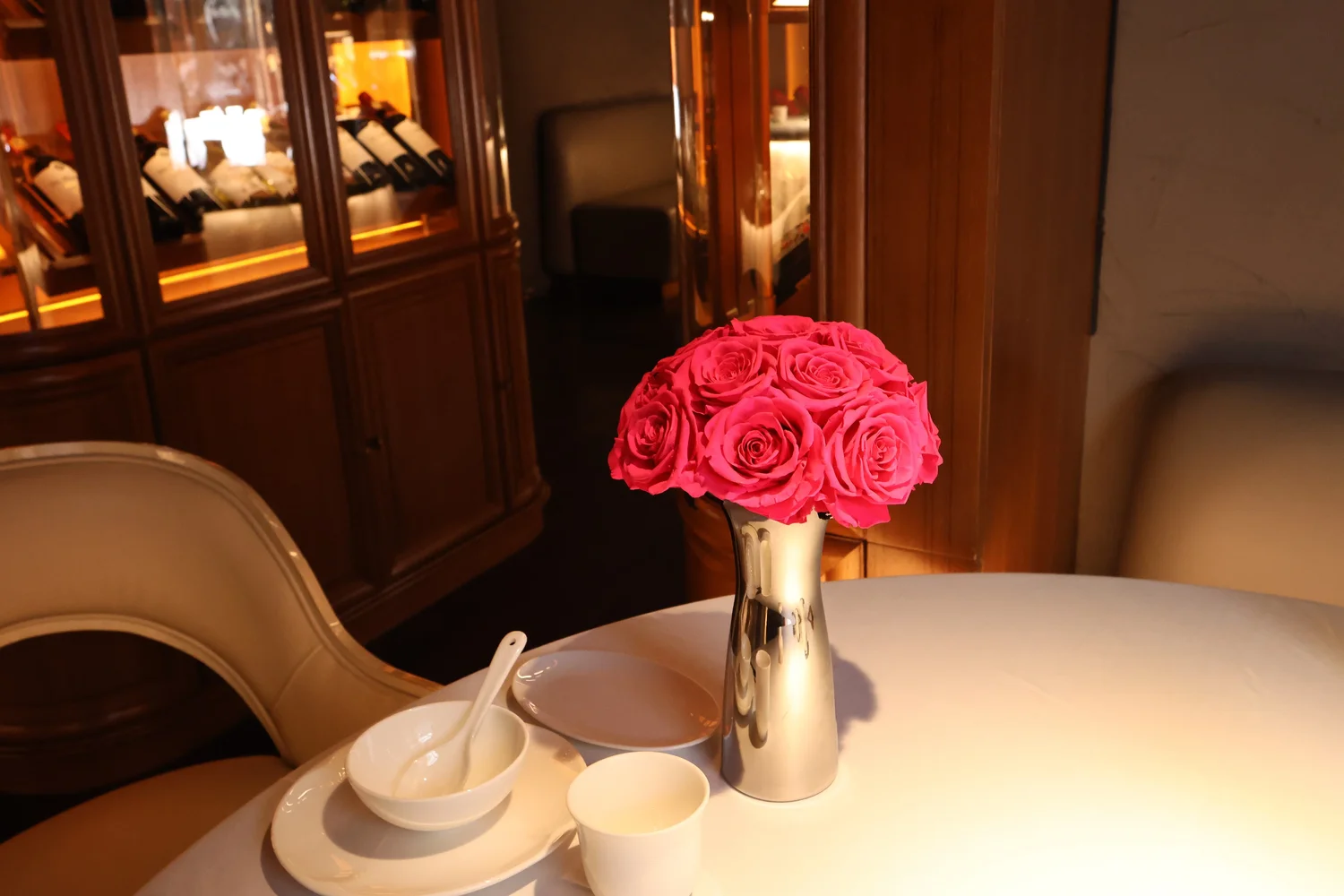 Cozy dining area with silver vase and roses