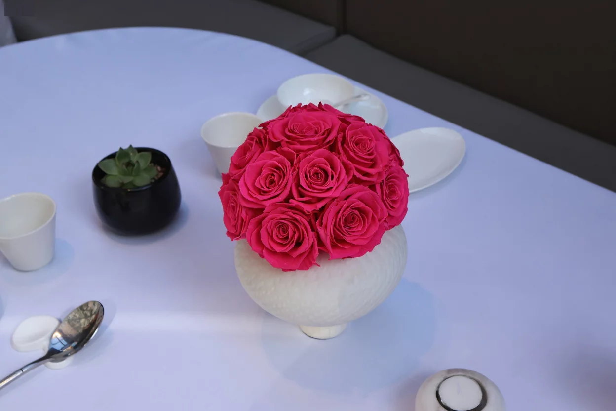 White textured ceramic vase with pink roses bouquet
