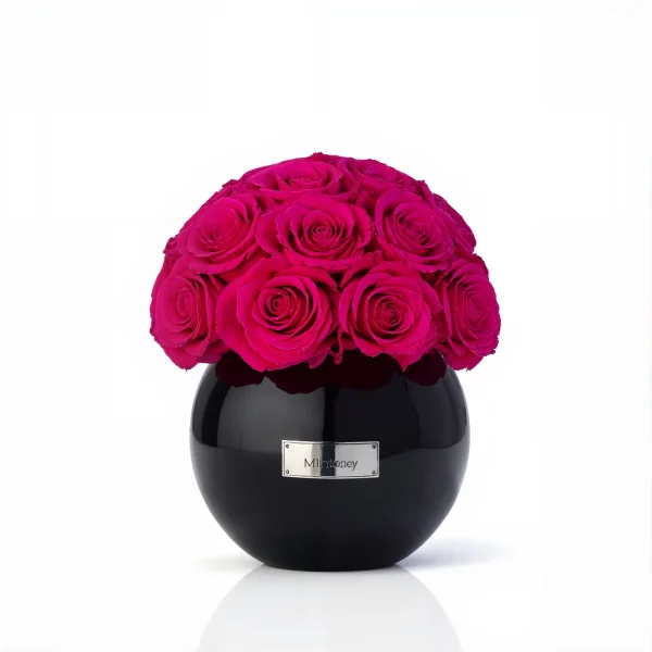Round black Minoan Homey vase with vibrant pink roses, modern floral composition against white background