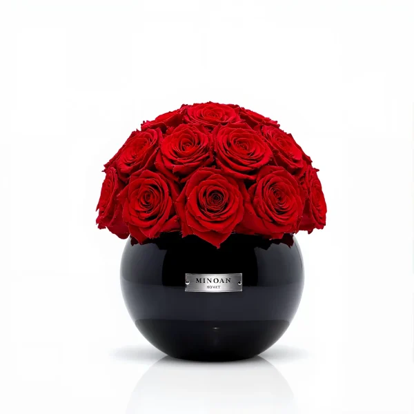 Glossy black Minoan Homey vase with deep red roses, luxurious floral arrangement on reflective surface