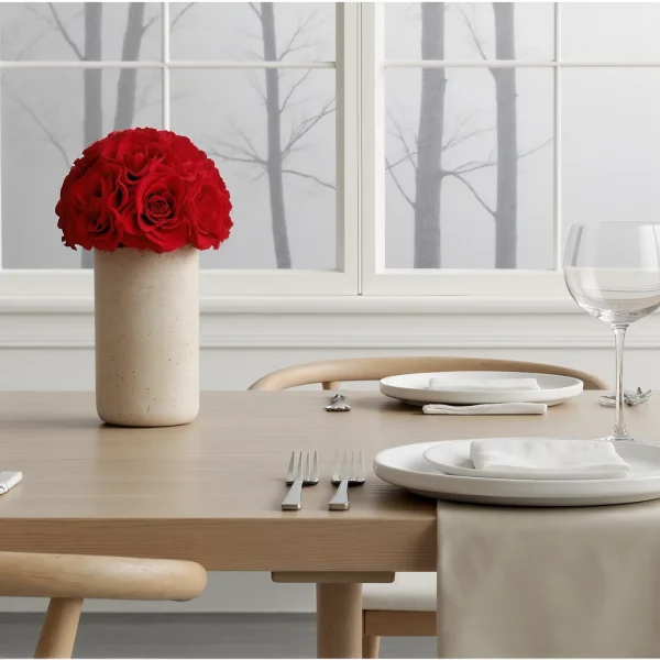 Modern dining room with red rose centerpiece and snowy tree view
