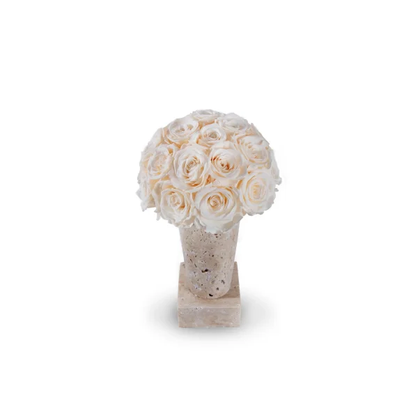 Decorative smooth pale beige stone vase containing lush bouquet of white roses on matching base against clean white