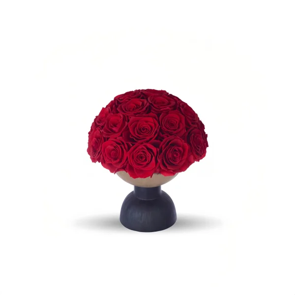 A photograph of a round, black pedestal vase holding a lush, vibrant bouquet of red roses. The roses are densely packed, with rich, velvety petals and dark green leaves peeking through. The vase is simple, modern, and sleek, with a matte finish. The background is stark white, creating a minimalist, elegant aesthetic that emphasizes the vivid red of the roses. The shadows cast by the vase and flowers are subtle, adding depth to the image.high quality, detailed, photograph , hd, 8k , 4k , sharp, highly detailed