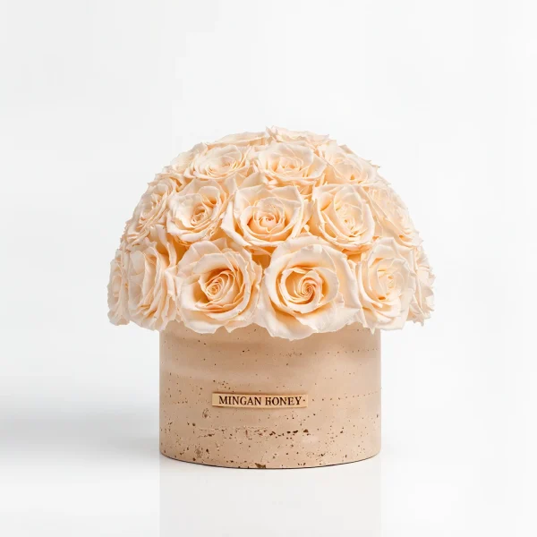 Spherical cream rose arrangement in beige vase