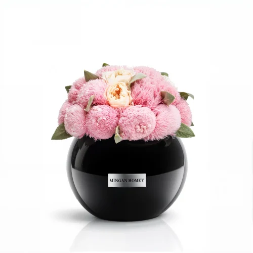 Glossy black Minoan Homey vase with pink chrysanthemums and peach roses, velvety floral arrangement