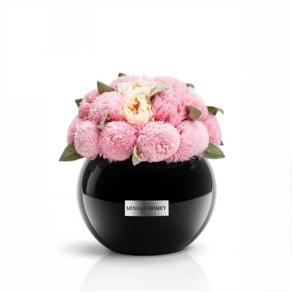 Glossy black Minoan Homey vase with pink chrysanthemums and peach roses, velvety floral arrangement